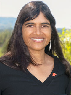 Dr. Anjali Oberai, Wawa seen from the shoulders up, wearing a black shirt, long black hair, and smiling