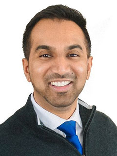 Dr. Shivajan Sivapalan, seen from the chest up, wearing a black sweater, short black hair, and smiling

