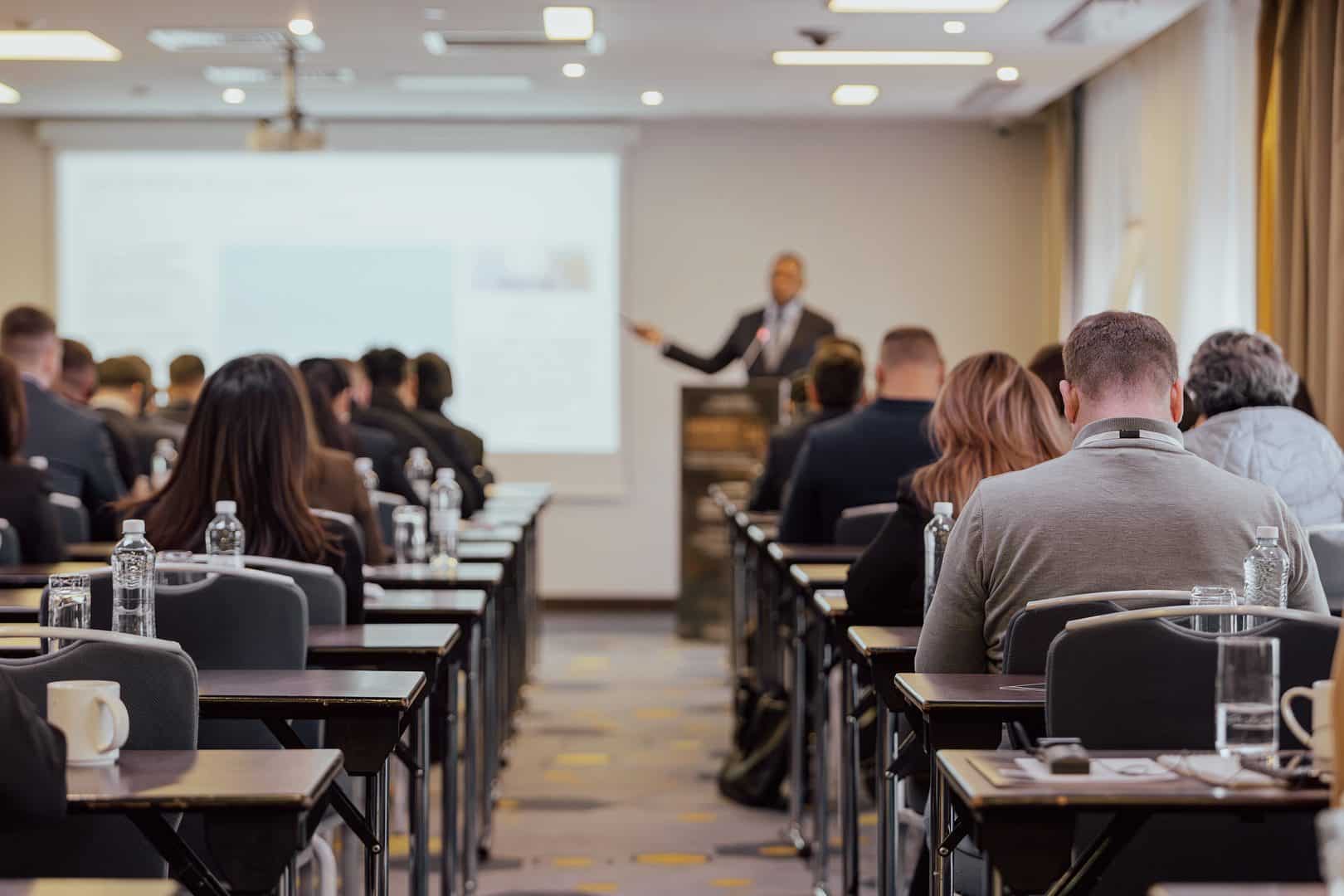 An image of a classroom with business professionals learning and looking at a presentation screen.